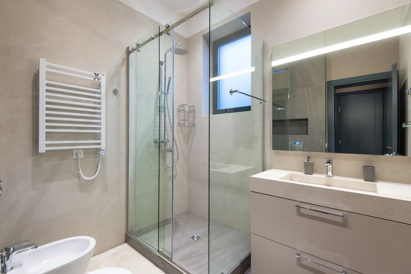 A bathroom with a glass shower enclosure and a floating vanity